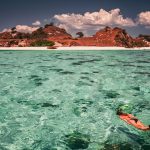 Snorkeler swimming near a tropical island in Komodo National Park