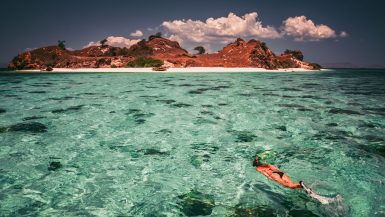 Snorkeler swimming near a tropical island in Komodo National Park